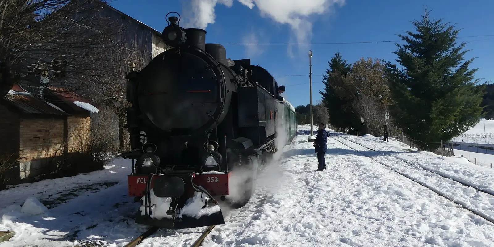 Dampfzug im verschneiten Bahnhof